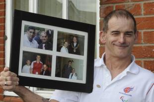 Tony holding a phograph of himself with other athletes.